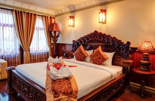 Chambre avec lit sculpté à l'Okay Boutique Hotel